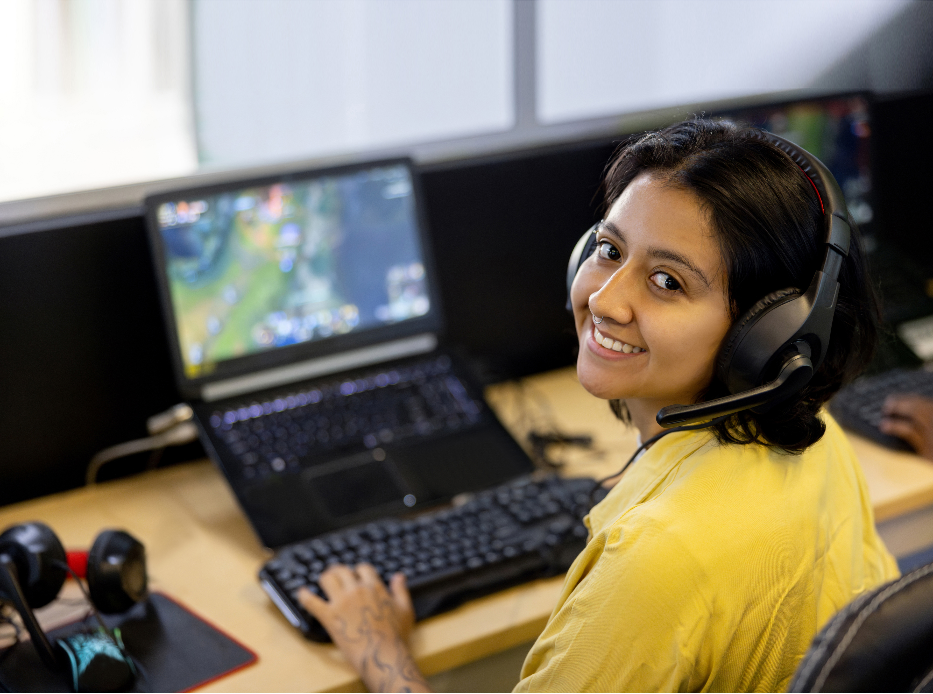 student sitting at a computer with headset on