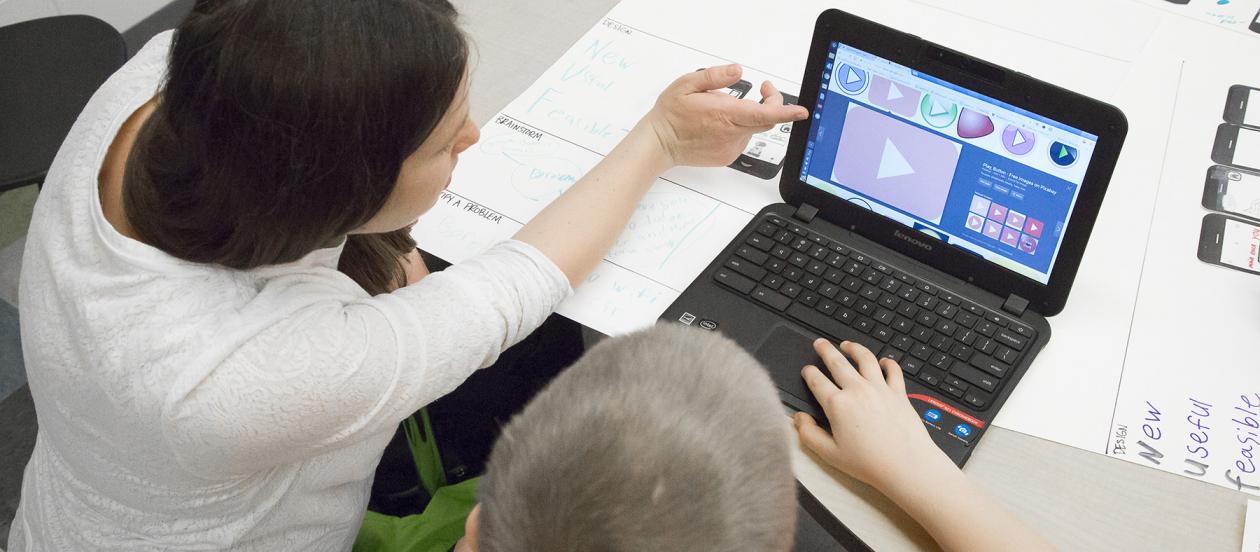iSchool student showing child how to create an app through App Authors