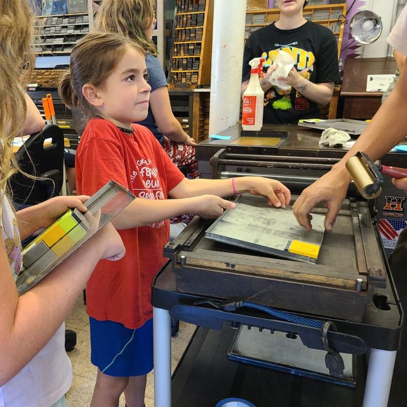 A camper participates in printmaking during summer camp at the Champaign-Urbana Community Fab Lab.