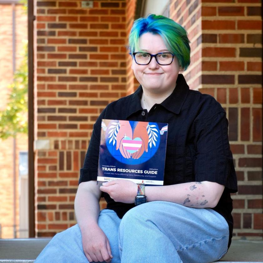 Mads Christiansen holds up trans resources guide