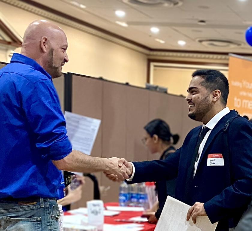 employer shaking hands with student at career fair