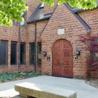 The double arched wooden doors at the entrance of the iSchool, a brick building at 501 E Daniel