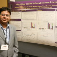 Shameem Ahmed poses next to the award-winning poster