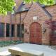 The double arched wooden doors at the entrance of the iSchool, a brick building at 501 E Daniel